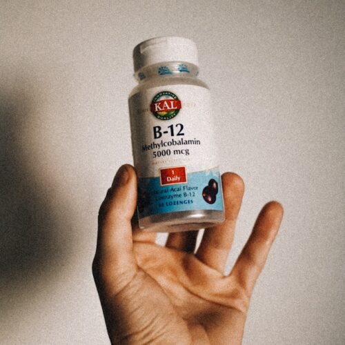 a person holding a bottle of vitamin b12